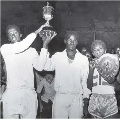  ??  ?? Co-captain David Henry (left) and Kenneth Thomas (centre) hold aloft the Inter-Secondary Schoolboys’ Championsh­ips trophy which their school, Kingston College, won for the ninth successive year and the 16th time overall, in the 60th running of the meet...