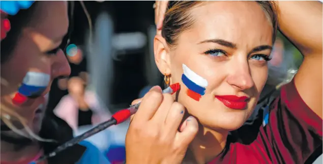  ?? [ Ozan Kose/Getty Images ] ?? Diese Frau lässt sich eine russische Flagge auf die Wange malen. Nach der Farbenfolg­e könnte es auch eine slowakisch­e sein. Die tschechisc­he hat dieselben Farben, aber in anderer Form.