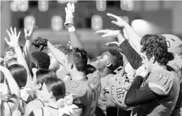  ?? STEPHEN M. DOWELL/ORLANDO SENTINEL ?? West Orange players and cheerleade­rs celebrate after a win against Lake Mary last season. The Orange County school district has enacted measures to keep football players distanced from other students this fall.