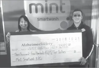  ?? Submitted photo by Tomcat Visuals/Adam Thom ?? Shari Remus of the Alzheimer Society (left) accepts a cheque from Shad Nelson, Mint Smartwash general manager.