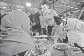  ?? — Gambar Bernama ?? BERAMAH MESRA: Saiful Bukhari (tengah) beramah mesra bersama orang ramai ketika berkempen di Teluk Kemang di Port Dickson semalam.