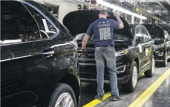  ?? THE CANADIAN PRESS ?? Workers inspect new Edge SUVs on a production line at the Ford plant in Oakville, Ont. The new USMCA agreement preserves Canadian-U.S. automotive trade that’s worth close to $150 billion a year.