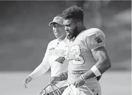  ?? CHUCK BURTON/AP ?? Panthers coaching intern Jennifer King, left, talks with Elijah Holyfield (33) during practice July 29 at training camp in Spartanbur­g, S.C.