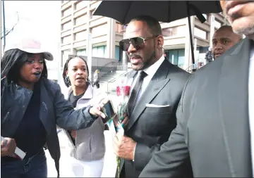  ??  ?? Fans giving Kelly a rose and cards, outside the Leighton Courthouse on Friday in Chicago, Illinois. Kelly had appeared before a judge to request permission to travel to aubai to work several concerts. — AFP photo