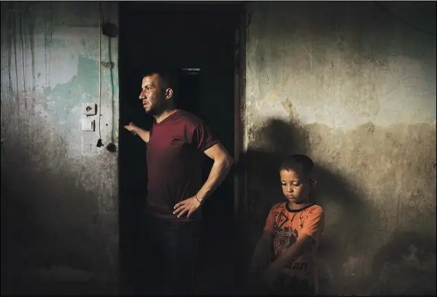  ??  ?? Jalal Nassir stands with his son June 12 in their home, damaged in an 11-day war between Israel and Hamas, the militant group that controls Gaza.