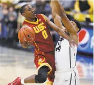  ?? David Zalubowski / Associated Press ?? USC guard Shaqquan Aaron drives for a basket as Colorado’s George King defends in the first half.