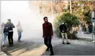  ?? PHOTO OBTAINED BY THE AP ?? In this photo, university students attend a protest inside Tehran University while a smoke grenade is thrown by anti-riot Iranian police, in Tehran, Iran, Saturday.