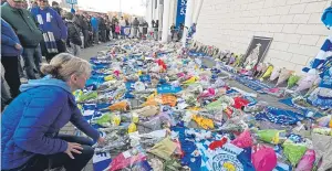  ??  ?? Flowers, football strips and scarves were laid outside the stadium yesterday