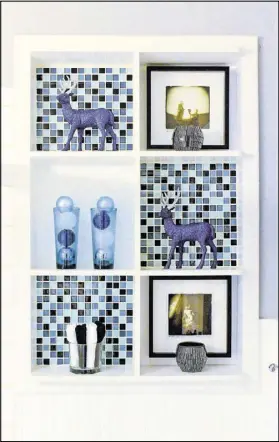  ??  ?? Joey Kendrick tiled the back of the built-in shelves in his guest bathroom. His goal was to add style while maintainin­g a masculine feel with blue and black hues. The framed photos, purchased at a Piedmont Park festival, stay there year-round, but the...