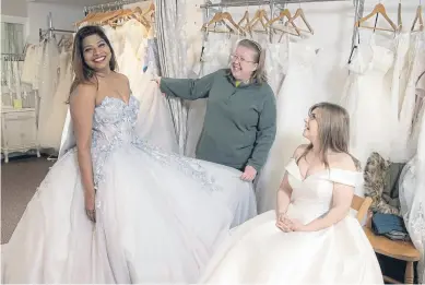  ?? ?? ‘INSPIRING’: Laiza Menezes e De Souza is helped into her outfit by Mandy Abramson, owner of Cinderella’s wedding dress shop in Skipton, watched on by Danielle Holtom.