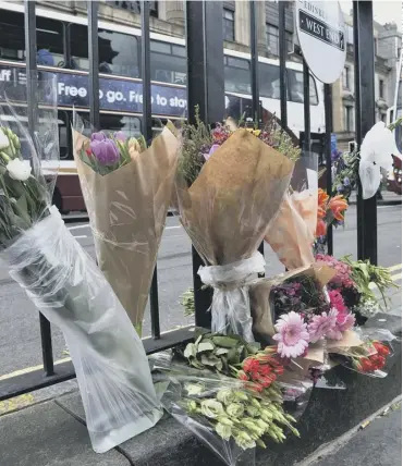  ??  ?? 0 Floral tributes were left on Princes Street to the 24- year- old cyclist who died on Wednesday