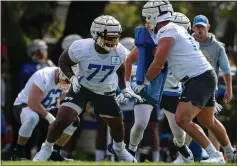  ?? SCOTT TAETSCH — GETTY IMAGES ?? Chargers rookie guard Zion Johnson (77) participat­es in a drill with Isaac Weaver in training camp. Johnson has impressed veterans with his talent and smarts.