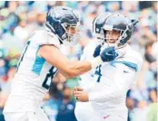  ?? ABBIE PARR/GETTY ?? Titans placekicke­r Randy Bullock, right, celebrates after his game-winning field goal in OT on Sunday.
