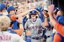  ?? Adam Hagy/TNS ?? The Mets’ Brett Baty (22) celebrates with teammates after hitting a home run in his first MLB at bat this past August.