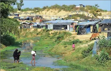  ??  ?? Rohingya Muslim refugees cross a canal next to a settlement near the no man’s land area between Myanmar and Bangladesh in Tombru in Bangladesh’s Bandarban on February 27.