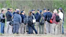  ?? TODD MCINTURF/DETROIT NEWS VIA AP ?? Investigat­ors huddle before traveling across a huge field to a dig site along a rural wooded area in Macomb Township, Mich., on Wednesday. Authoritie­s were set to resume excavation work to find the remains of a 12-year-old girl and the bodies of up to...