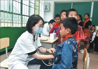  ?? PROVIDED TO CHINA DAILY ?? Volunteers from Shanghai provide free medical examinatio­ns for students at a primary school in Cangyuan Va autonomous county, Yunnan province, during an event organized by China Eastern.