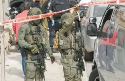  ?? MAHMOUD ILLEAN/AP ?? Israeli policemen secure the site of a shooting attack Saturday in east Jerusalem. A teen gunman wounded two people before he was taken into custody.