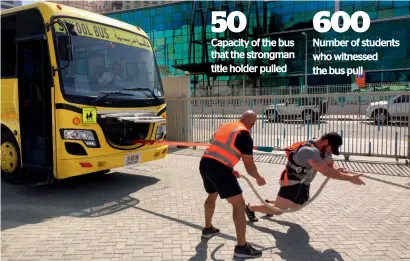  ??  ?? Mark Boyd hauls the 15-tonne school bus across the 30-metre parking lot of Gems Wellington Academy, Dubai Silicon Oasis.