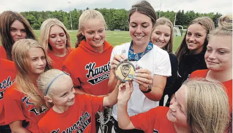  ?? CLIFFORD SKARSTEDT/EXAMINER FILE PHOTO ?? Erica Evans, 22, shows her gold medal from the 2015 FIL World Under-19 Women's Field Lacrosse Championsh­ip in Edinburgh, Scotland to players from Kawartha Women's Field Lacrosse on Aug. 1, 2018 at Trent University. Evans is named among Don Barrie’s top 100 local sports figures.