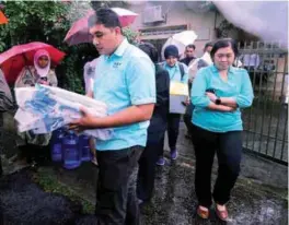  ??  ?? Police officers carrying documents and boxes from the Empower office as the NGO staff look on.