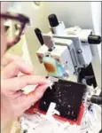  ?? ANNE-CHRISTINE POUJOULAT/AFP ?? A technician uses blades to cut out parts of a cancerous tumour packaged in parafin, for microscopi­c analysis, in the laboratory of pathologic­al anatomy of the PaoliCalme­tte Institute in Marseille.