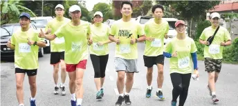  ??  ?? Dato Wong (front, second left) gives a thumbs-up as he and other runners from Ta Ann Group make their way to the finish line.