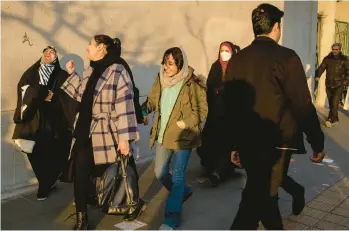  ?? ARASH KHAMOOSHI/THE NEW YORK TIMES ?? Women, including several wearing head coverings, walk Jan. 28 in Tehran, Iran.