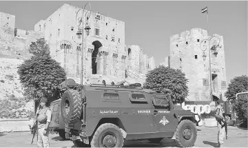  ??  ?? File photo shows Russian military police patrolling outside the medieval Citadel of Aleppo, in the eponymous northern Syrian city. — AFP photo