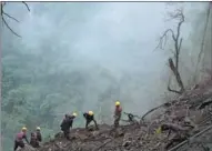  ??  ?? Workers brave the rain to clean up the rubble from the tunnel entrance. The subtropica­l monsoon climate brings long succession of wet days, which is extremely inconvenie­nt and dangerous for the workers.