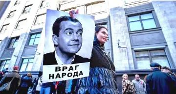  ??  ?? A protester holds a picture of Medvedev bearing an inscriptio­n reading ‘An enemy of people’ during a rally against the pension reform in front of the State Duma, the lower house of parliament, in Moscow. — AFP photo