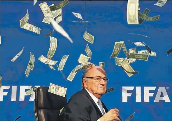  ?? ARND WIEGMANN / REUTERS ?? Blatter se ve sorprendid­o ayer por una nube de billetes falsos de un dólar que le lanzó en la rueda de prensa un cómico británico