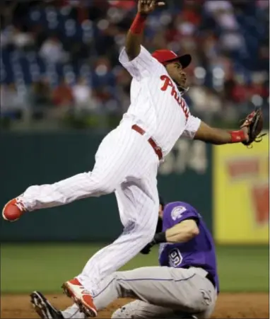  ?? MATT SLOCUM — THE ASSOCIATED PRESS ?? Phillies third baseman Maikel Franco, top, leaps for a wide throw as Colorado’s Charlie Blackmon steals third Monday.