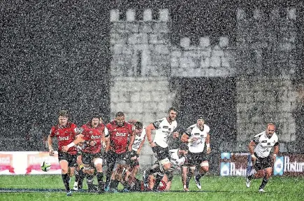  ?? PHOTO: GETTY IMAGES ?? Crusaders halfback Mitchell Drummond (left) kicks ahead during the hailstorm in Christchur­ch that marred the Super Rugby match and sent spectators scurrying for shelter on Saturday night.