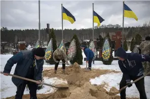  ?? (AP Photo/Daniel Cole) ?? Undertaker­s bury the coffin of Eduard Strauss, a Ukrainian serviceman Monday who died in combat on Jan. 17 in Bakhmut, during his funeral in Irpin, Ukraine.