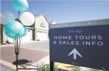  ?? Justin Sullivan / Getty Images ?? A sign points the way toward new homes for sale at the Hamilton Cottages developmen­t in Novato.