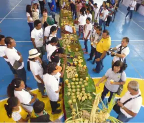  ?? CONTRIBUTE­D PHOTOS ?? THE 48-foot long table showcasing food products of Dagyaw Food Services Group (left photo) and members of Peacepond Farmers Associatio­n (right photo) preparing the “Libon Timbulog” products of Ituman-magahat-bukidnon weavers during showcase and launching activity in Binalbagan town on Thursday.