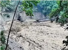  ?? ?? The damaged steel bridge over the flooded Teesta River in north Sikkim's Chungthang region on October 4 (AFP)