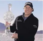  ?? ERIC RISBERG/ASSOCIATED PRESS ?? Phil Mickelson poses with his trophy on the 18th green of the Pebble Beach Golf Links after winning the AT&amp;T Pebble Beach ProAm on Monday.