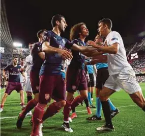  ?? REUTERS PIC ?? Arsenal’s Matteo Guendouzi (third from right) and Henrikh Mkhitaryan (fourth from right) try to calm down Valencia’s Gabriel Paulista (right) in a Europa League semifinal second leg match on Thursday.
