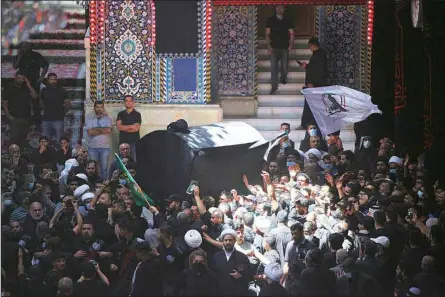  ?? (AP) ?? Mourners carry the coffin of Grand Ayatollah Mohammad Saeed al-Hakim, inside the holy shrine of Imam Hussein during his funeral procession in Karbala, Iraq, Sept. 4. Mohammed Saeed al-Hakim, one of Iraq’s most senior and influentia­l Muslim Shiite clerics, has died, members of his family said. He was 85.