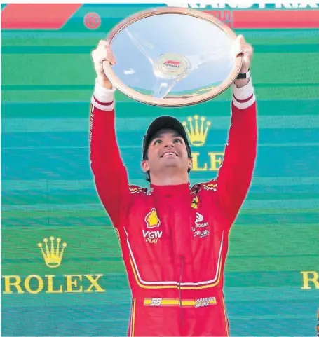  ?? FOTO: SCOTT BARBOUR/AP ?? Der spanische Ferrari-Pilot Carlos Sainz (M.) genießt seinen Sieg auf dem Podium.