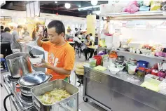  ??  ?? Vegetarian food seller Ooi Kim Yew. - Bernama photo