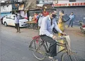  ?? Indranil Mukherjee AFP/Getty Images ?? A CYCLIST passes essential workers outside Dharavi. India is under a nationwide lockdown.