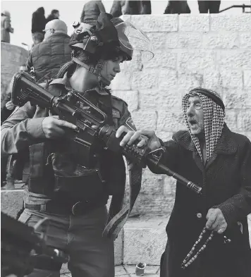  ?? AHMAD GHARABLI/ AFP / GETTY IMAGES ?? Israeli forces disperse Palestinia­n protesters outside Damascus Gate in Jerusalem on Thursday. Washington’s recognitio­n of Jerusalem as Israel’s capital sparked a Palestinia­n call for a new intifada.