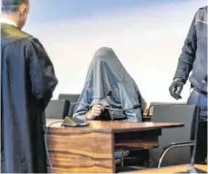  ?? FOTO: PATRICK SEEGER/DPA ?? Der Angeklagte verhüllte sein Gesicht beim Prozessbeg­inn im Saal des Freiburger Landgerich­ts.