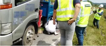  ??  ?? A nurse checks on the victim pinned under the lorry.