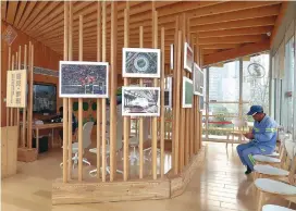  ??  ?? A sanitation worker rests in a service center at the Huangpu River waterfront in Pudong. Twenty-two such “public living-rooms” will be built along the waterfront walkway. — Wang Rongjiang