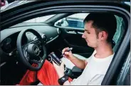  ?? BLOOMBERG ?? An employee uses an electronic handheld device as he performs a quality control check on the interior of an Audi automobile at the Audi AG production plant in Gyor, Hungary.