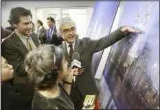  ?? JOYCE DOPKEEN — THE NEW YORK TIMES ?? The architect Rafael Violy, center, discusses his team’s plan to rebuild the World Trade Center site with reporters in New York in 2003. The governor picked a different design.